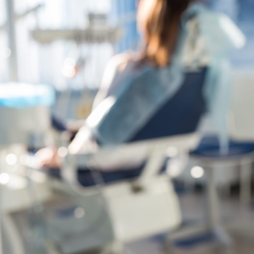 blur image of woman sitting in the dentists office for background usage